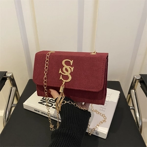Burgundy suede shoulder bag with gold S-logo buckle and fringe tassel detail