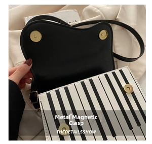 Detailed shot of the gold magnetic closure on a handbag with piano key pattern