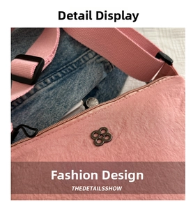 Close-up of pink nylon fabric texture with metallic clover logo and adjustable strap