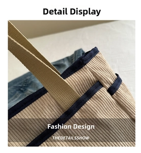 Macro detail of beige corduroy tote bag featuring dark blue canvas trim and reinforced stitching
