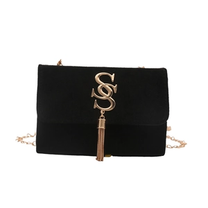 Retro black faux suede crossbody bag with gold double S chain and tassel on white background