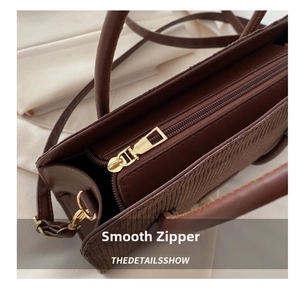 Top view of smooth gold zipper and dark brown corduroy texture on retro handbag