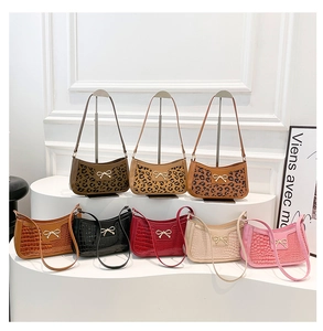 Gros plan de sacs sous les bras à motif léopard et crocodile avec nœud métallique chic
