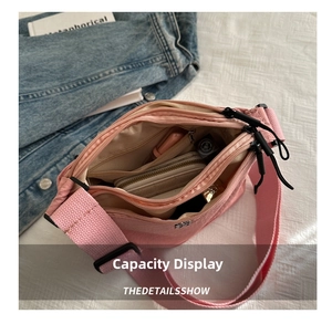 Detail view of the pink nylon crossbody bag showing spacious multi-layer zipper compartments