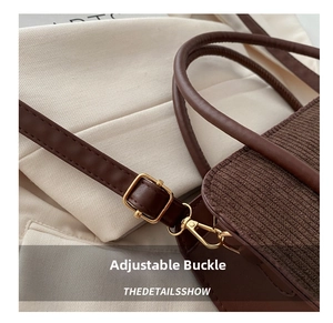 Detailed close-up of dark brown corduroy texture and adjustable gold metal buckle on strap
