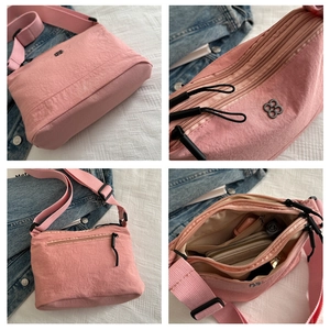 Pink nylon crossbody bag with multiple compartments and adjustable wide shoulder strap