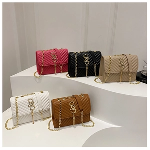 Detailed view of five quilted chain crossbody bags in various colors on display stands