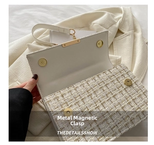 Detailansicht des goldenen Magnetverschlusses einer cremeweißen Tweed-Handtasche