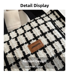 Detail of checkered tweed texture and brown leather patch on minimalist tote bag