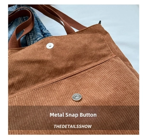 Close-up of a magnetic snap closure on a brown corduroy tote bag with fine stitching