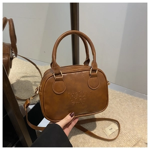 Macro shot of the brown matte leather Boston bag with embossed Lucky LHCO Smu lettering detail