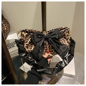 Dettaglio borsa baguette leopardata con fiocco in raso nero e tracolla arricciata