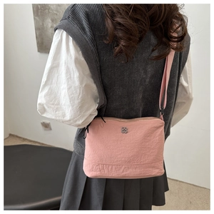 Pink nylon crossbody bag shown from behind on a model to display size and fit