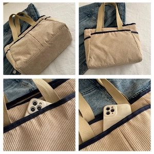 Detail of beige corduroy tote bag with blue trim and front pocket for daily storage