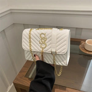 White quilted faux leather crossbody bag with gold chain strap and metal tassel detail