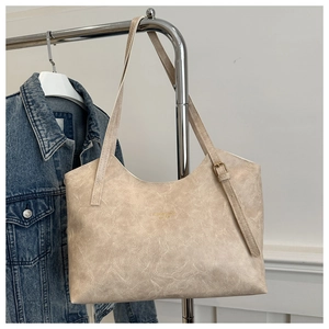 Detail of beige tote bag showing marble texture synthetic leather and gold buckle