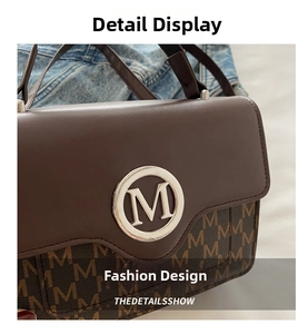 Detail of retro small square bag showing brown leather flap with metal M logo and monogram pattern