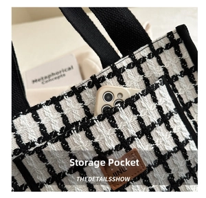 Close-up of exterior pocket on black and white plaid wool tote with leather logo detail