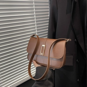 Schicke braune Leder-Umhängetasche mit goldener Schnalle zu einem modernen Blazer-Outfit