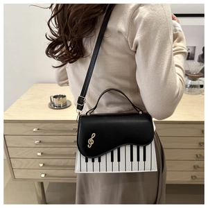 Close-up of piano keyboard pattern handbag with golden treble clef metal decoration