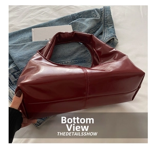 Detail view of the vintage burgundy tote bag base featuring reinforced stitching and shiny leather
