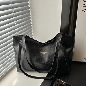 Large black leather tote bag with gold lettering and slim shoulder straps for women