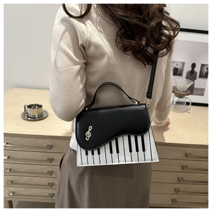 Detail showing creative piano key design and golden musical note logo on the crossbody bag