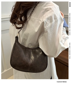 Detailed view of vintage brown crossbody bag with metallic chain strap and matte texture