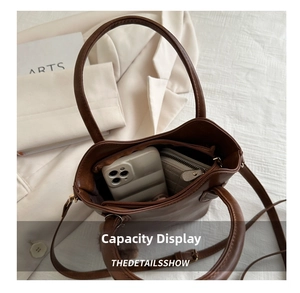 Detail view of large capacity dark brown bucket bag showing interior space for phone and wallet
