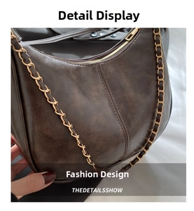 Detail of vintage brown shoulder bag showing cracked leather texture and chain strap