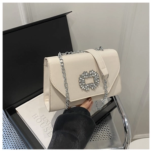 Detail of elegant cream white PU leather envelope bag with luxury crystal buckle and chain