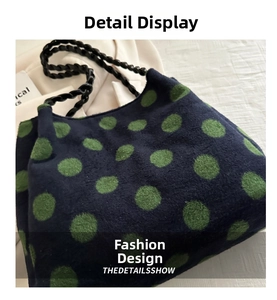 Détail macro du sac cabas en tricot bleu marine avec pois verts et bandoulière tressée