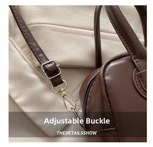 Close-up of adjustable silver metal buckle and strap on dark brown leather crossbody bag