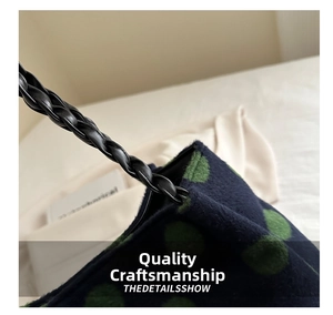 Macro detail of dark blue dotted velvet fabric with black braided leather shoulder strap