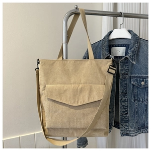 Detail of beige corduroy tote bag showing soft texture and adjustable shoulder strap