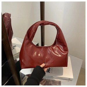 Détail du sac hobo en cuir verni bordeaux avec poignée sans couture et fini brillant