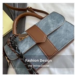 Detailed close-up of denim and brown leather handbag with woven rope and metal charm