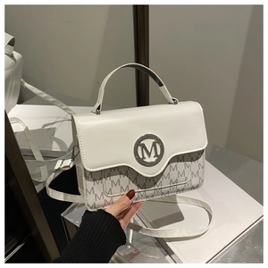 Detail of white leather shoulder bag featuring metallic M logo and monogram pattern