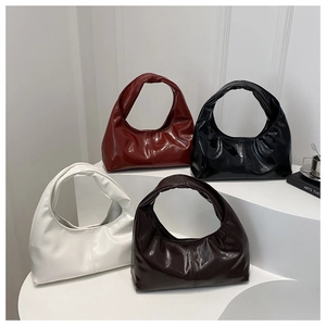 Détail de quatre sacs fourre-tout en cuir brillant en bordeaux, noir, blanc et marron