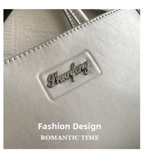 Detail of silver leather square bag featuring metallic logo and premium stitching