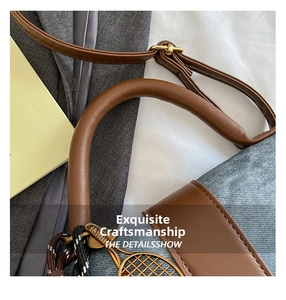 Close-up of blue denim and brown leather handbag with a metal tennis racket charm
