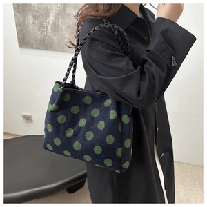 Détail du sac cabas en laine bleu marine à pois verts et bandoulière tressée sur modèle