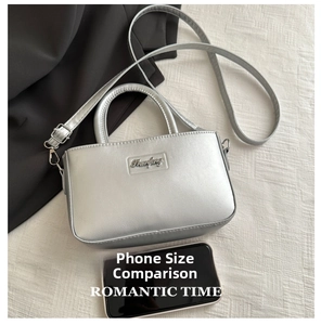 Silver metallic leather crossbody bag size comparison with a smartphone for scale