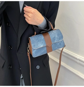 Detail of vintage denim and brown leather handbag with adjustable crossbody strap