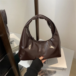 Minimalist dark brown glossy tote bag with sleek crescent design and mirror reflection