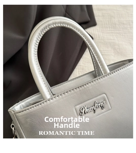 Detail of silver metallic tote bag showing thick round handle and Phaofeng brand logo
