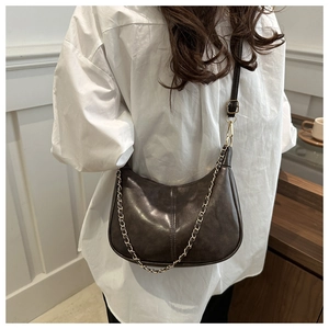 Detail of a dark brown PU leather crescent tote bag with golden chain and shoulder strap