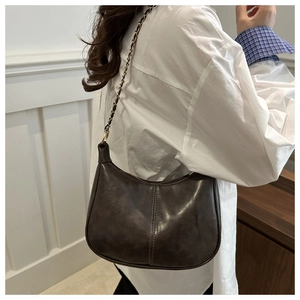 Detail of dark brown faux leather tote with chic chain strap and vertical seam stitching