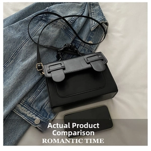 Detail of black rectangular crossbody bag showing size comparison with a smartphone