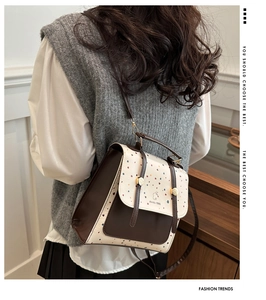 Rear view of a model wearing the brown and cream polka dot faux leather backpack